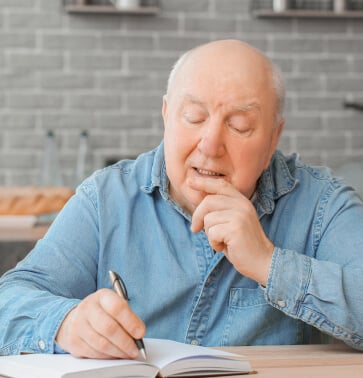 older man writing in journal